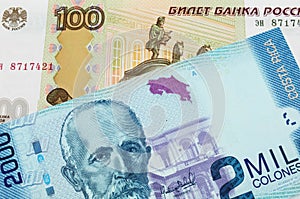 A Russian one hundred ruble note paired with a colorful two thousand colones bank note from Costa Rica.