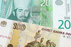 A Russian one hundred ruble note paired with a green and white twenty dinar banknote from Serbia.