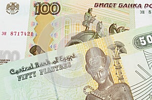 A Russian one hundred ruble note paired with a green and yellow fifty piastre note from Egypt.