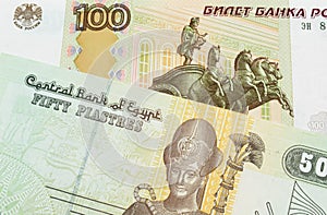 A Russian one hundred ruble note paired with a green and yellow fifty piastre note from Egypt.