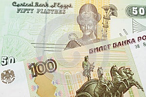 A Russian one hundred ruble note paired with a green and yellow fifty piastre note from Egypt.