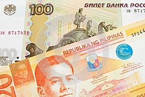 A Russian one hundred ruble note paired with a orange and white twenty piso note from the Phillipines.