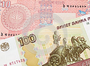 A Russian one hundred ruble note paired with a red ten taka bank note from Bangladesh.