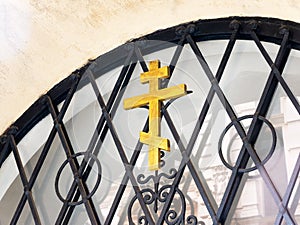 Russian Orthodox wooden cross symbol on a metal gate closeup, detail shot. Eastern Orthodox Christianity religious symbols concept