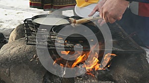 Russian pancakes on frying pan on bonfire