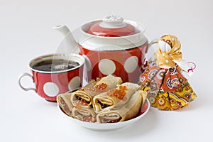 Russian pancakes with Red caviar with teapot, tea cup and textile doll isolated on white for Maslenitsa festival