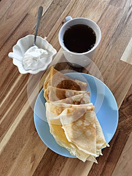 Russian pancakes with sour cream on a wooden table. Traditional Russian, Ukrainian food. Symbol of baby, seeing off winter.