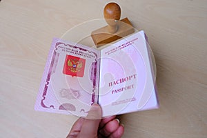 Russian passport in hand foreign International biometric passports of citizen of Russian Federation with red cover, stamp. Stop