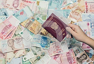 Russian passport with money of south-east Asia and American hundred dollar bill. Currency of Hong Kong, Indonesia, Malaysi