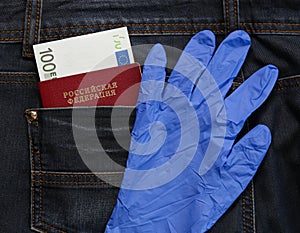 Russian passport in the pocket of jeans with blue glove, 100 euros money, tourism