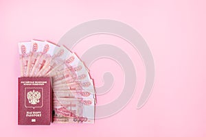 Russian passport and Russian money 5000 rubles on a pink background