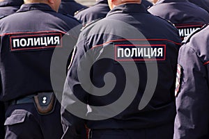 Russian police officers on patrol in the town square. View from the back. The inscription on the uniform: the police