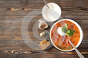 Russian red soup , ukrainian borscht with parsley and  sour cream  , garlic, bread, spoon, top view, soup