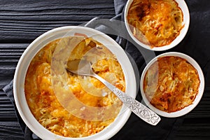 Russian Romanoff casserole made from potatoes, sour cream and cheddar cheese close-up in a pan. horizontal top view