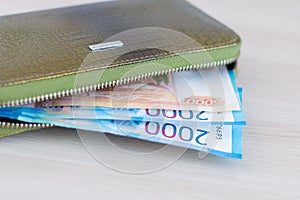 Russian rouble.Wallet with money on a light background. Two and five thousand bills in a green leather wallet on the table.Space