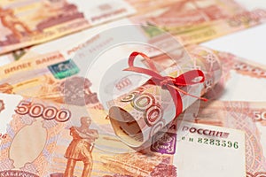 Russian roubles with red bow isolated on the money background.