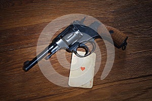 Russian roulette - Ace of Hearts plaing card and revolver with one cartridge in drum