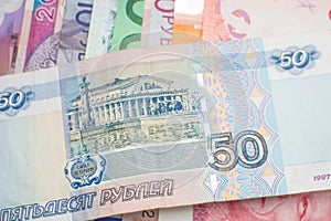 Russian Ruble banknote over a rainbow of international banknotes