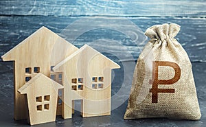 Russian ruble money bag and figurines of residential buildings. Property tax. Increase investment attractiveness