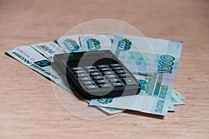 Russian rubles and calculator on a brown table