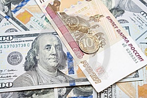 Russian rubles paper banknote and coin on american dollars as a symbol of beginning of a financial crisis in russia