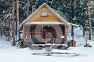 Russian sauna banja house in winter forest nearby the lake with ice-hole