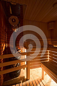 Russian sauna bathhouse with muted intimate light from under the bottom of bench wooden lantern hygrometer thermometer