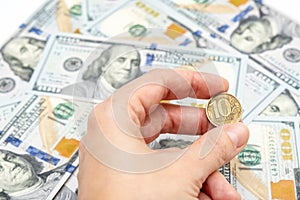 Russian ten ruble coin in a hand on american dollar background, financial loss and impoverishment of people concept