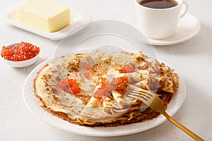 Russian thin pancakes or blini with red caviar.