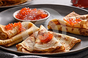 Russian thin pancakes or blini with red caviar on white. Top view. Pancake week. Shrovetide.