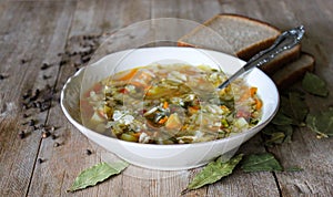 Russian Traditional cabbage, meat soup Shchi on white plate on natural wooden table background