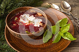 Russian traditional cuisine, red borscht made of beetrot, vegetables and meat with sour cream, winter hot rustic soup