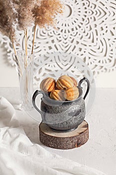 Russian traditional homemade cookies Nuts with condensed milk on an vintage jar on a wooden stand