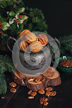 Russian traditional homemade cookies Nuts with condensed milk on an vintage jar on a wooden stand surrounded by spruce branches