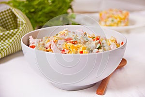 Russian traditional salad Olivier with vegetables and meat in the white bowl