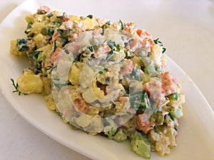 Russian traditional salad Olivier with vegetables and meat. Winter salad