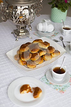 Russian traditional teaparty with samovar and pies or pirozhki with apple jam