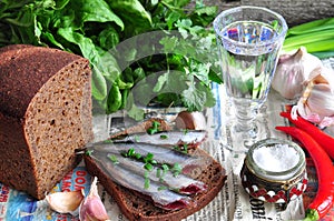 Russian traditions open sandwich with a sardines on rye bread with the wineglass of vodka