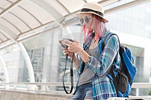 Russian traveller with backpack checking picture taken by her ca