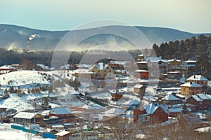 Russian village winter. Roofs covered with snow, a Blizzard sweeps in the forest