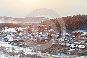 Russian village winter. Roofs covered with snow, a Blizzard sweeps in the forest