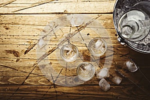 Russian vodka in shot glasses on wooden table, iced strong alcohol drink in misted glass. Top view, negative space