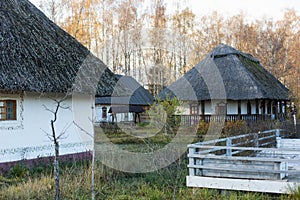 russian white rustic house in autumn with a roof of reeds.