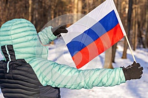 A Russian woman holds an open flag of Russia, Winter scenery, Russian national colors, Concept, manifesting attachment to the