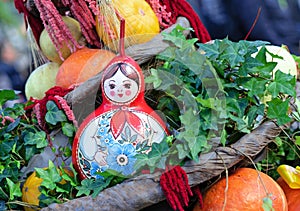Russian wooden doll Matryoshka in composition with pumpkins.