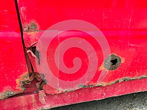 Rust detailes on an old red abandoned car near roadside