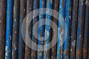 Rust metal vertical lines background blue tubes scaffold industrial iron texture