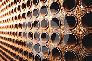 Rust tube sheet of the heat exchanger for maintenance, the water heater in the boiler as background wirh light