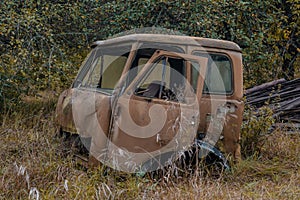 Rusted abandoned cabin of a truck in the grass at Chernobyl town