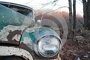 Rusted antique green car headlight